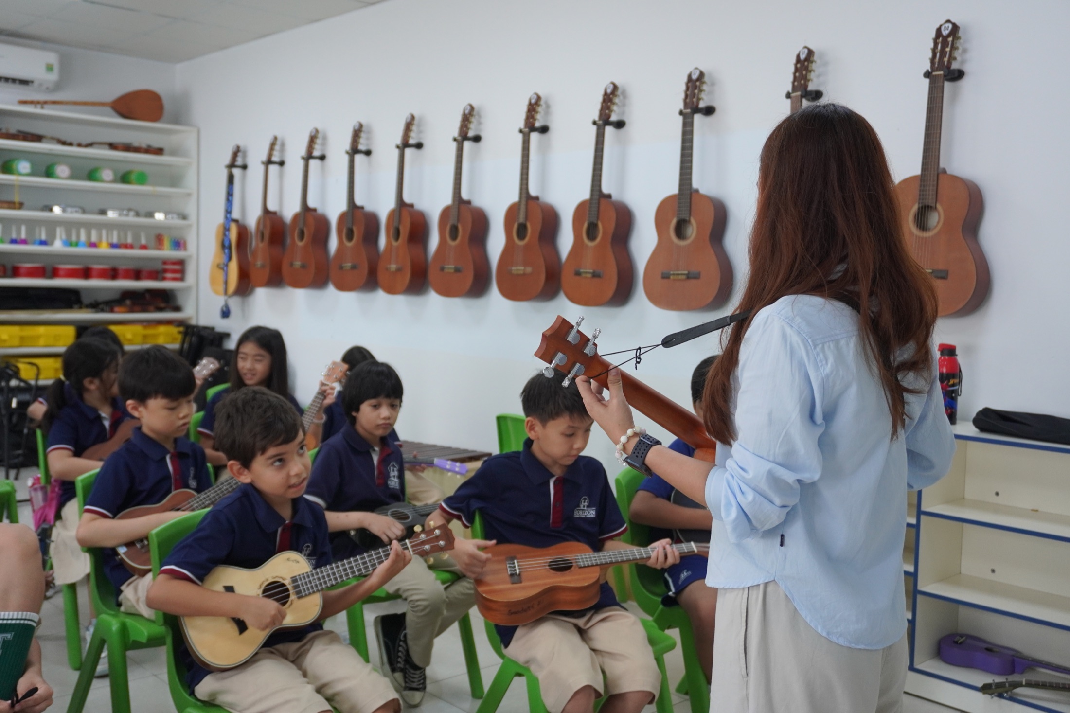 Horizon students learning to play ukulele with their music teacher